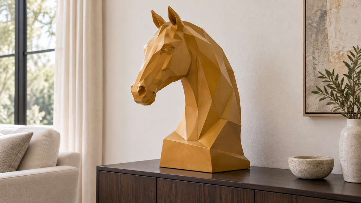 Ochre-colored faceted horse head on a dark wood console in a neutral living room.