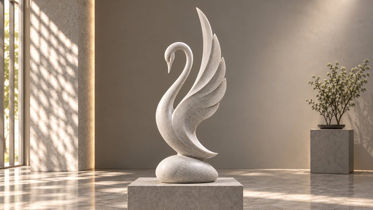White swan sculpture with layered flowing wings on a pedestal in a softly lit interior.