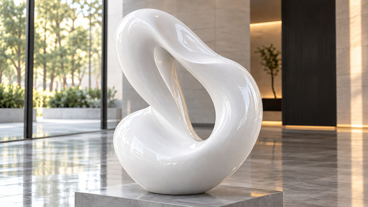 Glossy white fiberglass loop sculpture with an open curved form in a modern interior.