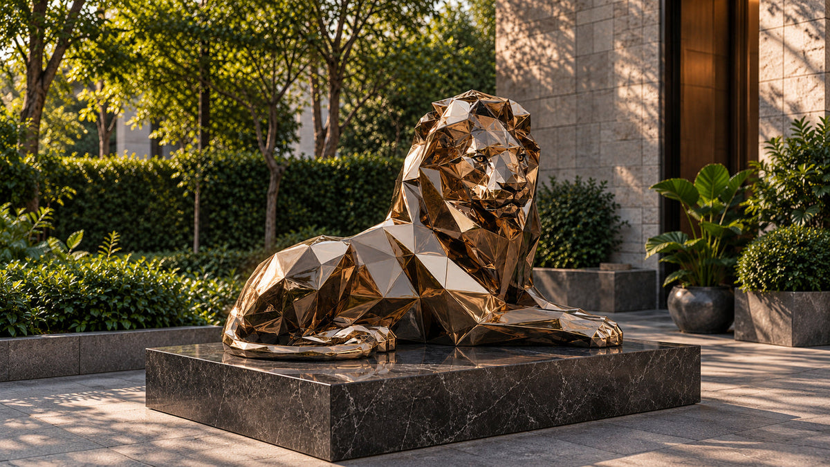 Bronze-toned geometric reclining lion sculpture on a dark marble base in a leafy courtyard.