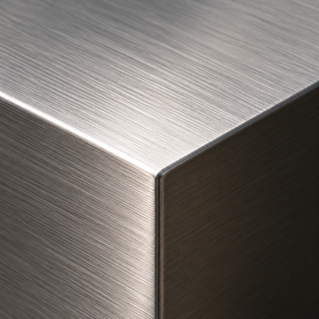 Close-up of a brushed stainless steel surface showing a clean linear metal finish and refined texture.