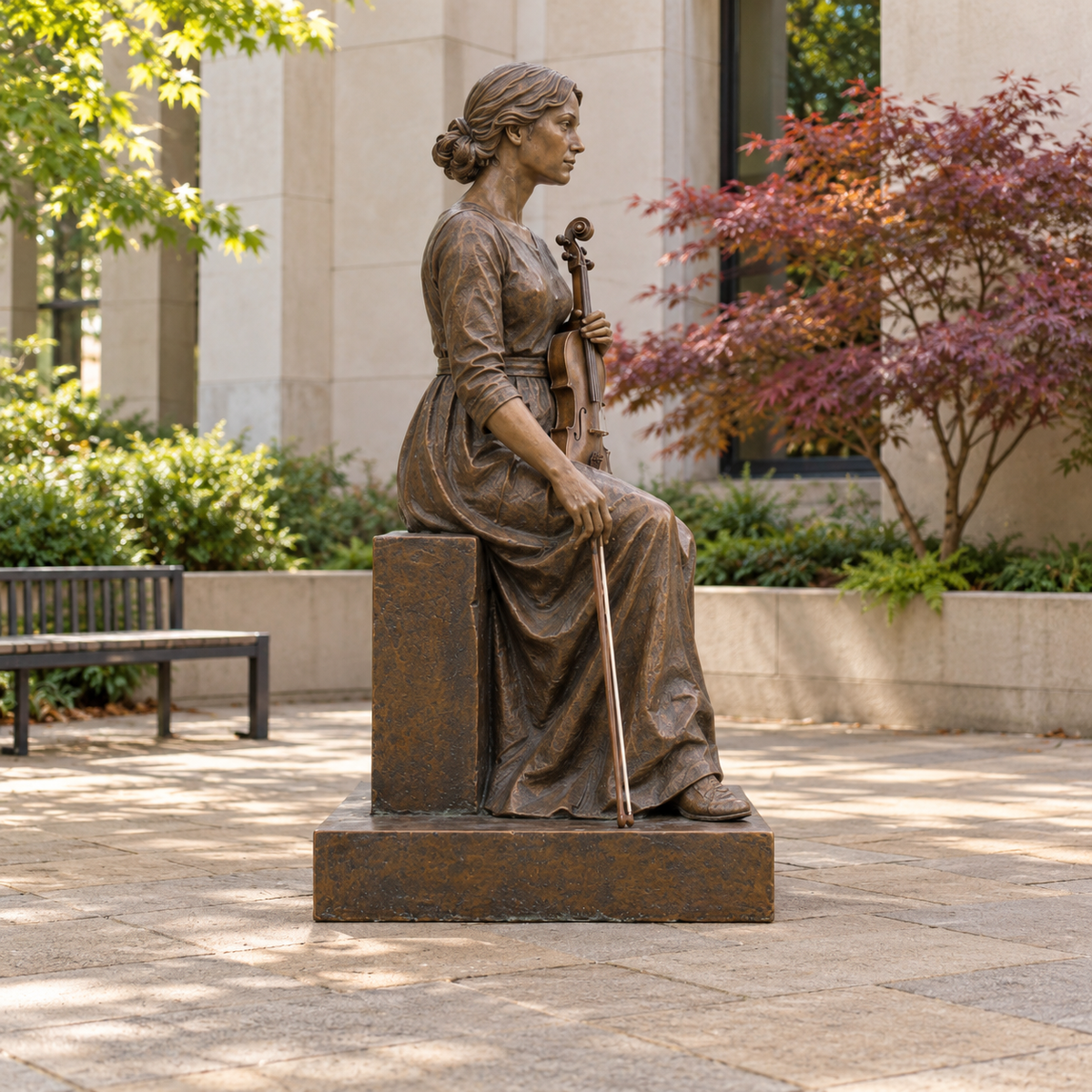 Side profile of Craft of Memory bronze seated violinist sculpture in a different architectural or garden setting.