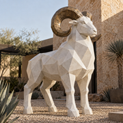 Desert Sovereign stone white and bronze fiberglass geometric ram sculpture displayed in a desert-modern resort courtyard