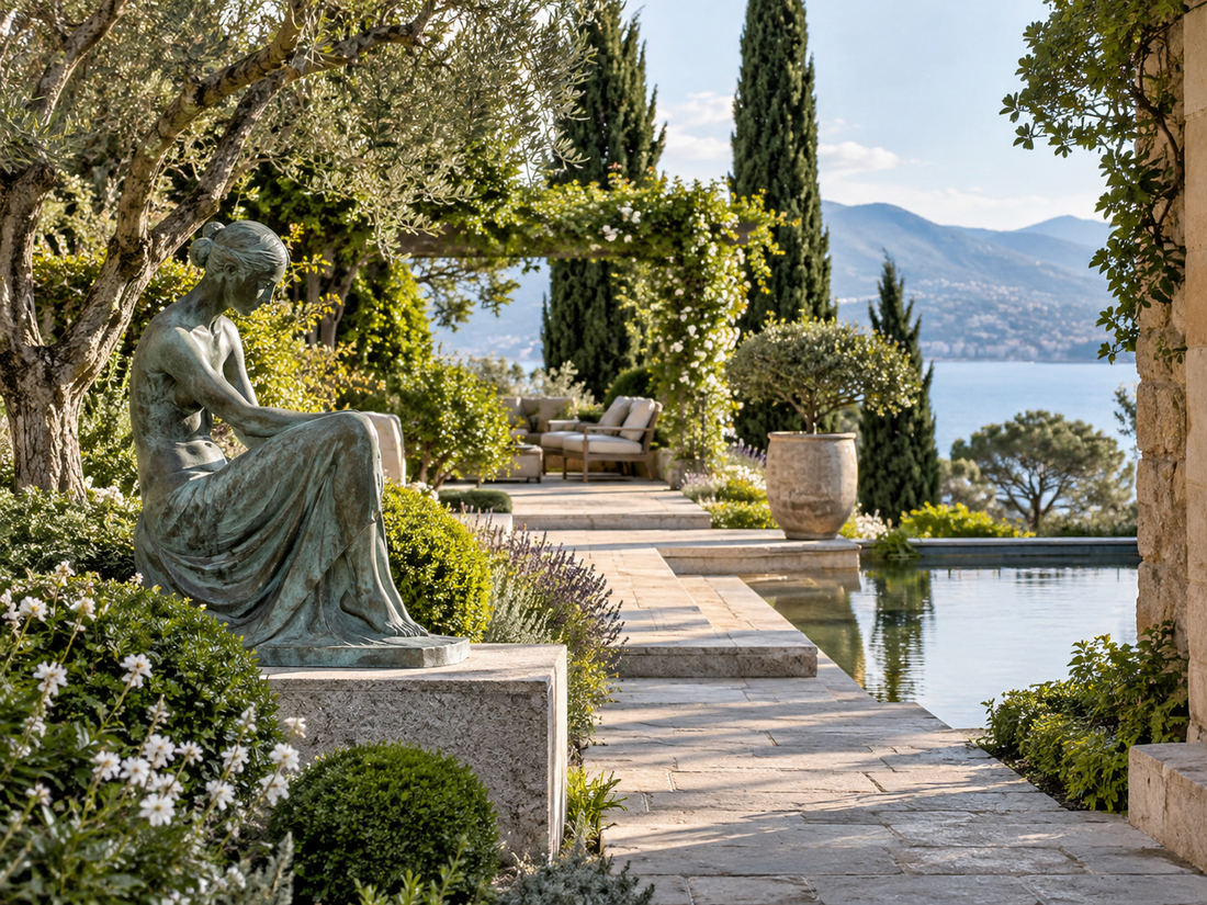 Seated figure sculpture in a landscaped garden beside water.
