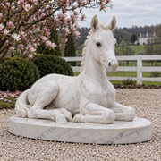 Foal's Reverie white marble resting foal sculpture in natural daylight.