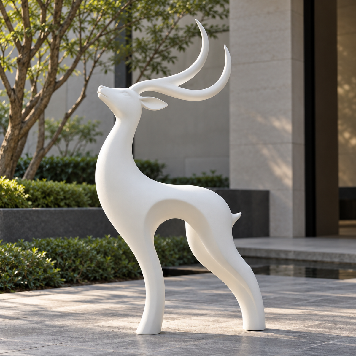 White fiberglass modern deer sculpture displayed in a contemporary residential courtyard with landscaped greenery and natural daylight.
